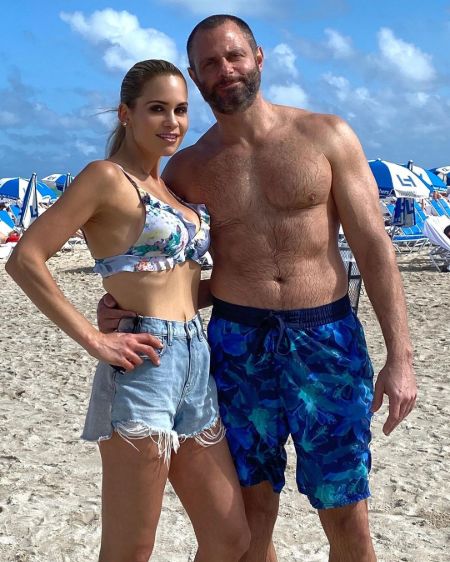 Jackie Goldschneider and her husband Evan Goldschneider posing for a picture at a beach.